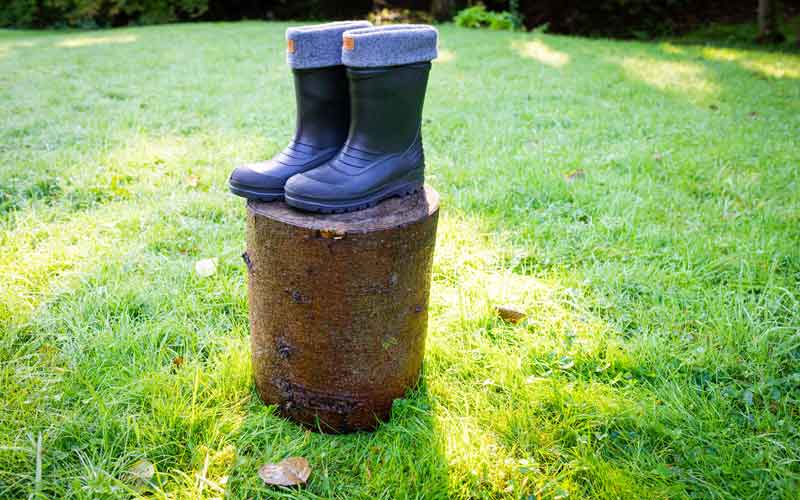 Kravat Gummistiefel auf einem Baumstamm